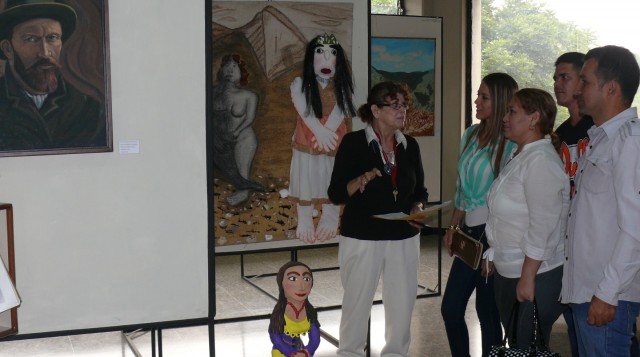 Rosamaría León, organizadora de la muestra, le explica a un grupo de asistentes los alcances de cada una de las obras expuestas