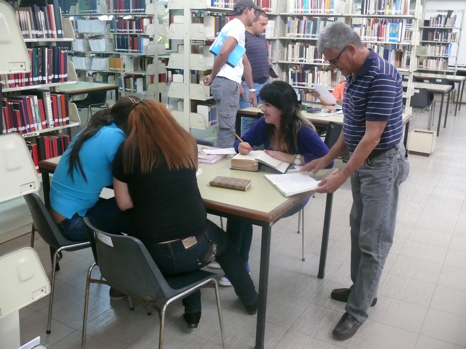 Emilio Becerra, (camisa a rayas) el trabajador más antiguo de la B.P:C “Leonardo Ruiz Pineda” en su trabajo diario: cumplir a cabalidad y con efectividad la labor de ser bibliotecario.