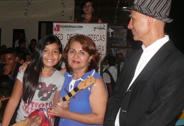 María José Carrero, ganadora de la categoría ‘B’ recibe como premio un cuatro de parte de isa Rangel, encargad de la B.P.C.