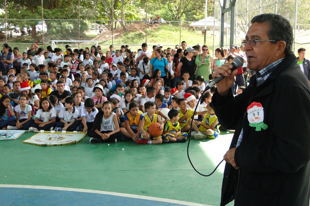 Enrique Noguera, director de Educación junto a los niños en la cancha Quinimarí. Foto: Prensa Dirección de Educación.